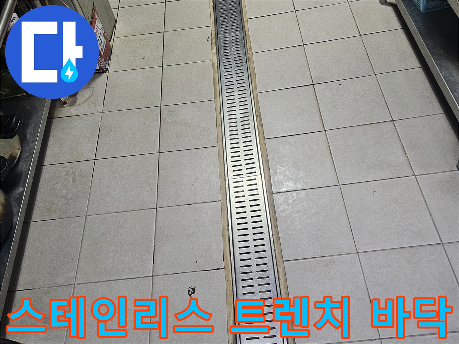 식당 주방 내 스테인리스 재질의 긴 배수 트렌치 구조물