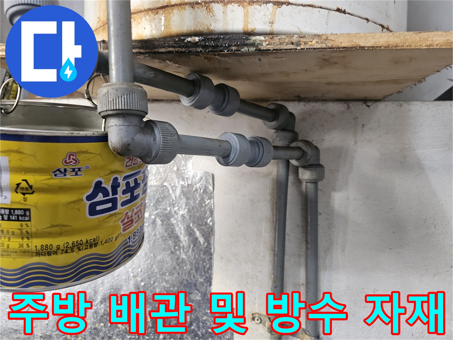 식당 주방 배수 트렌치 주변의 배관 연결 부위와 방수 작업을 위한 보조 자재 모습