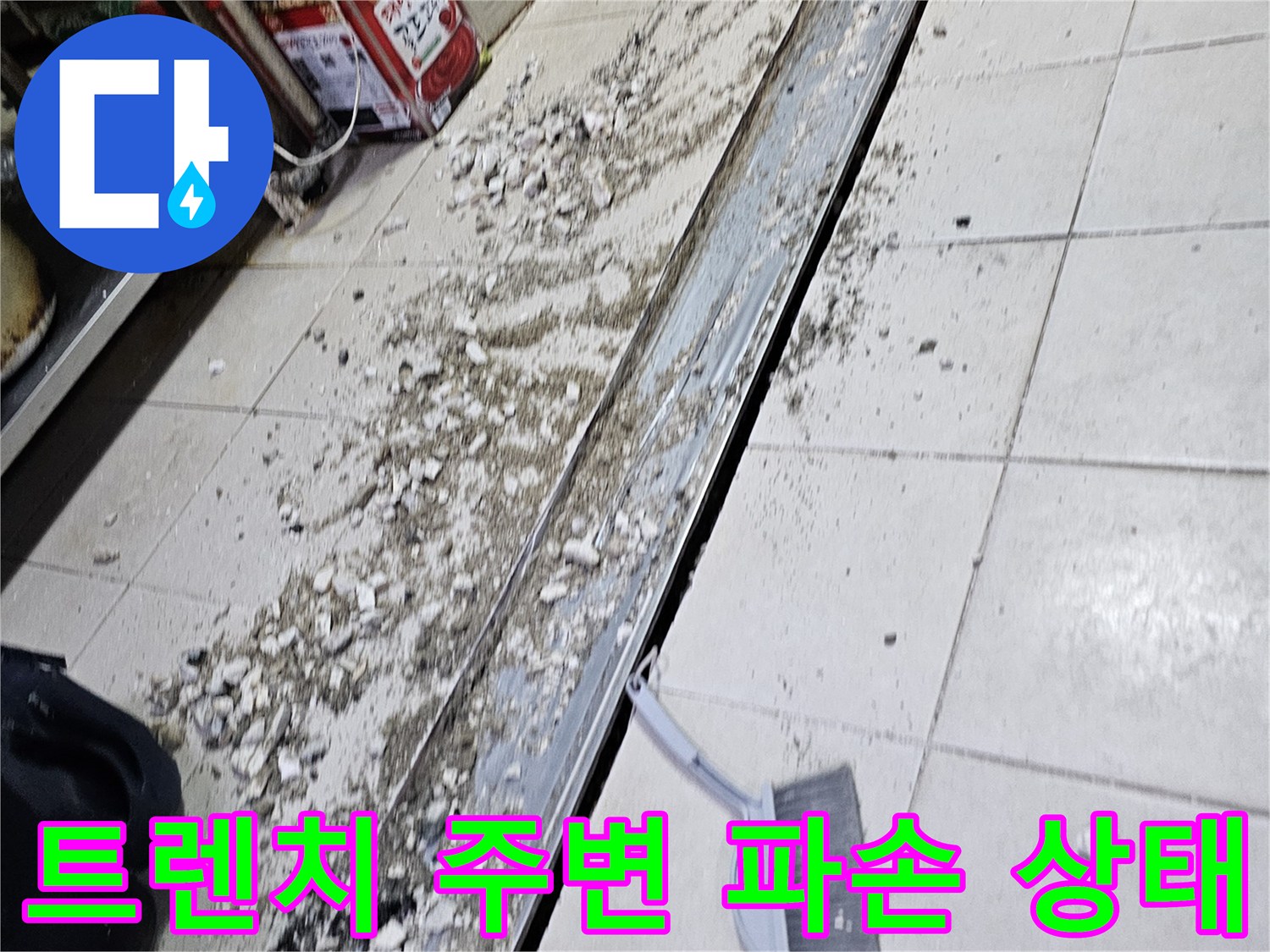 식당 주방 배수 트렌치 주변의 타일 틈새와 파손된 마감 부위
