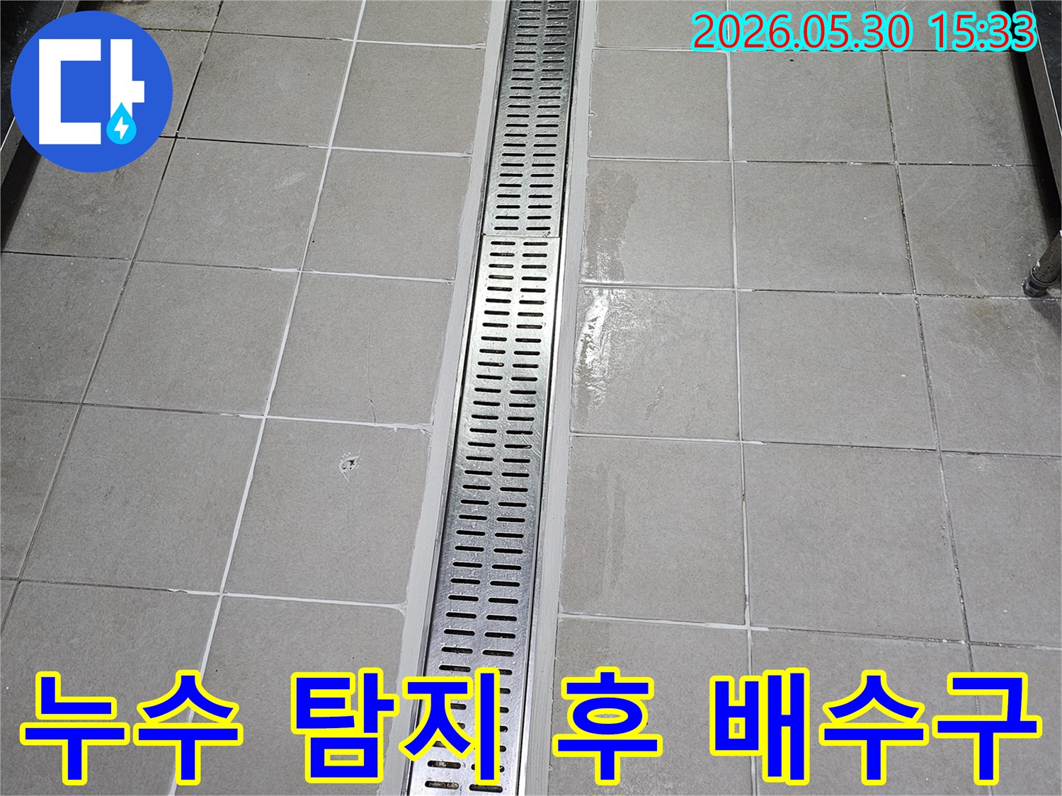 타일 벽면에-새롭게 설치된-스테인리스 선형 배수구-물이 고이지 않고-빠르게 배수되도록-시공된 모습