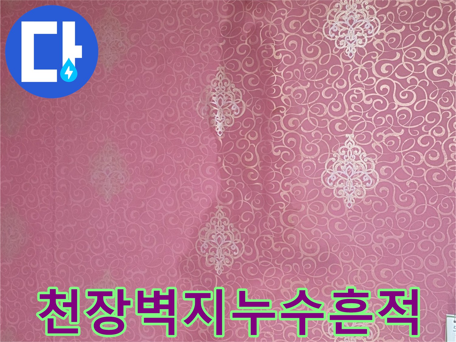 분홍색 패턴 벽지에 나타난 갈색 누수 얼룩과 변색된 부위