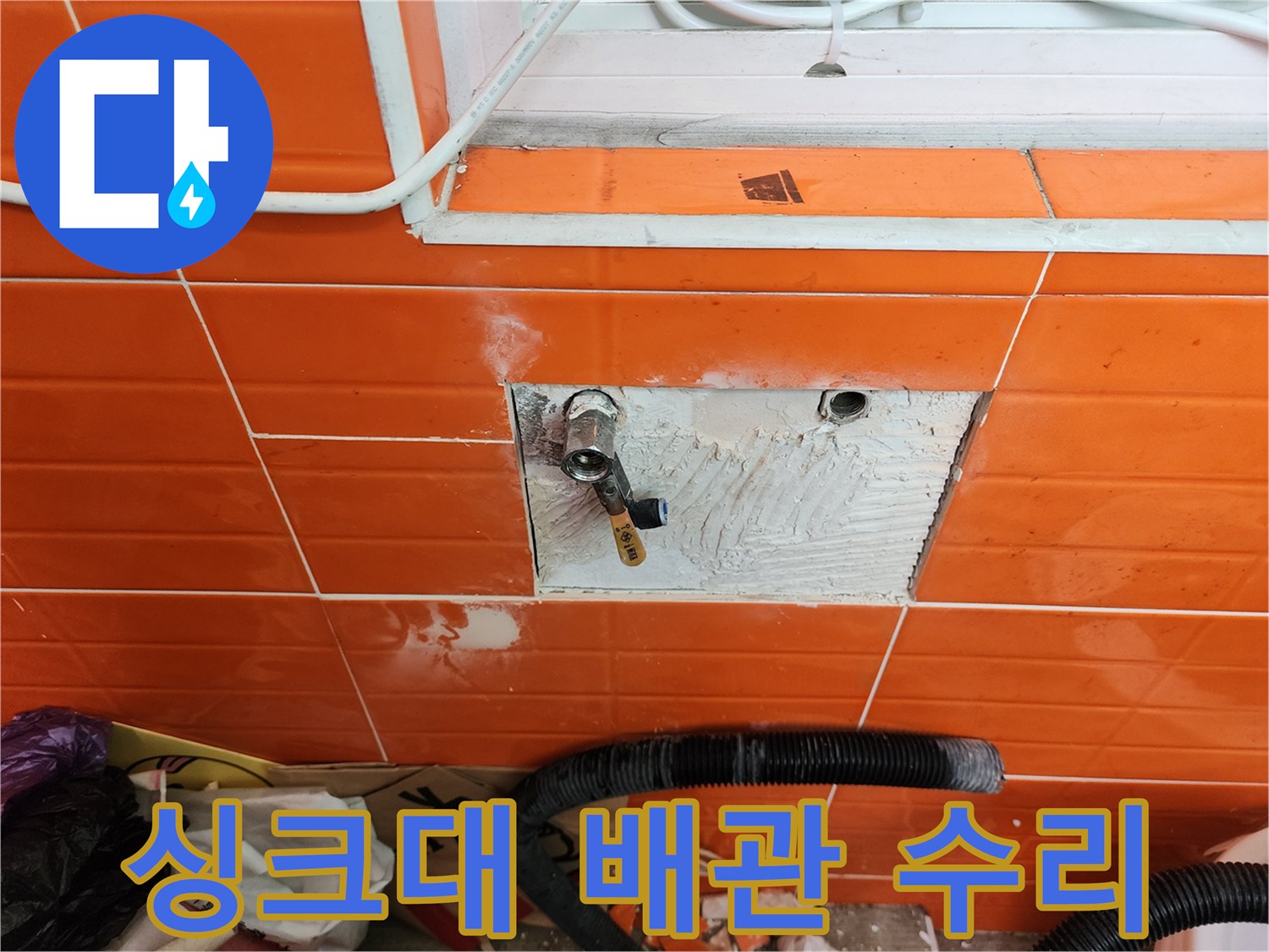 싱크대 아래 벽면의-타일을 제거하고-누수된 수도 배관을-수리하는 작업 현장