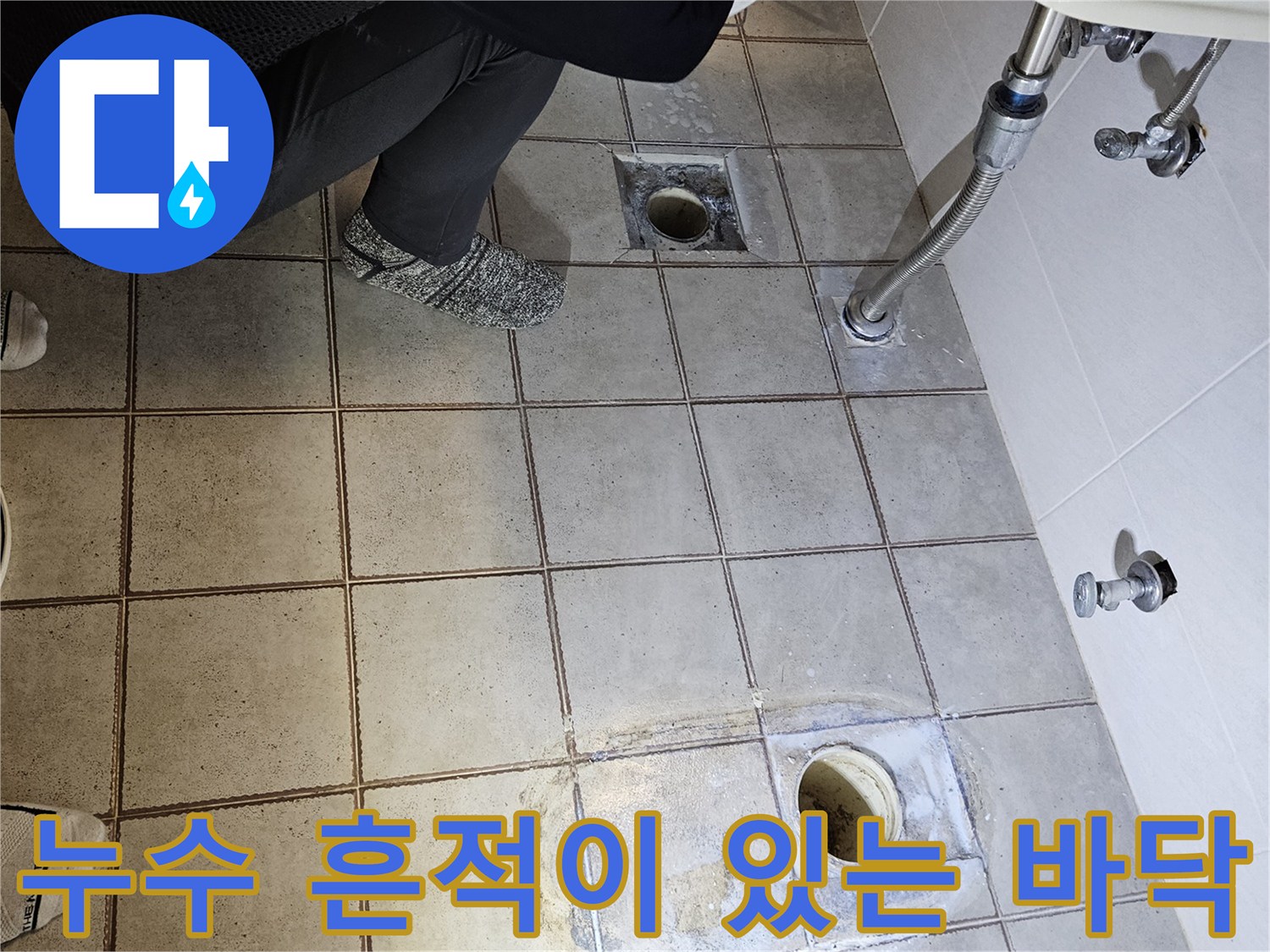 배관 주변의 젖은 타일과 변기 탈거 후 드러난 하수구 상태
