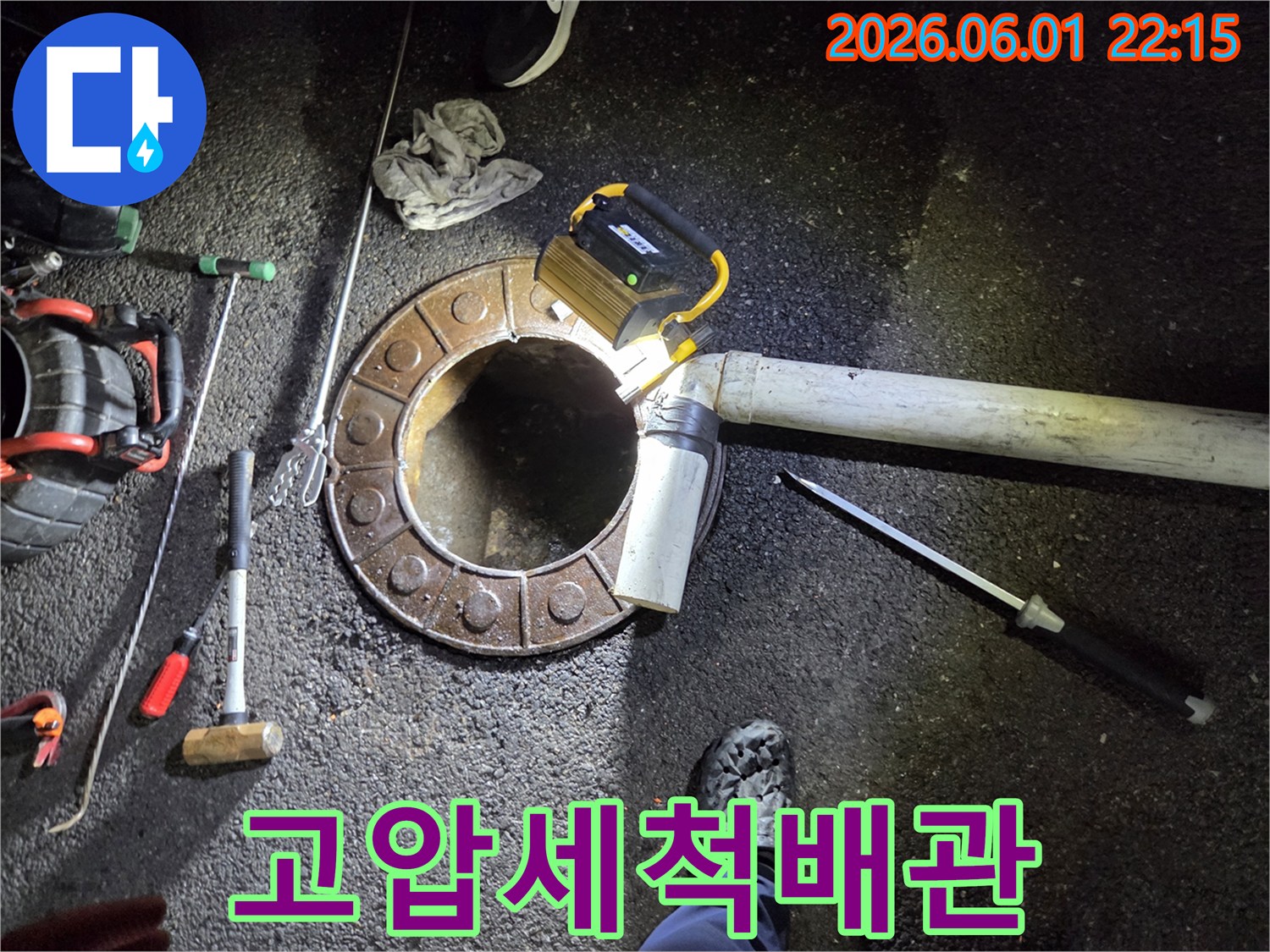 파쇄된-맨홀-주변에서-배관-청소를-진행하는-숙련된-기술자