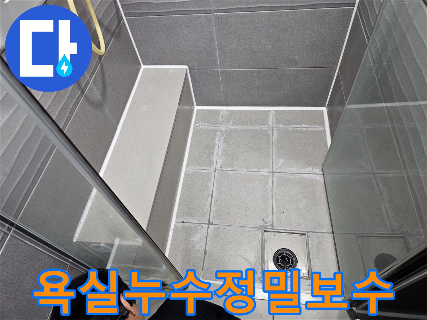 강동구 천호동의 아파트 욕실에서-누수 원인을 정밀하게 진단하고-바닥 타일 줄눈을 새롭게 보수하는 전문 기술자의 모습입니다.