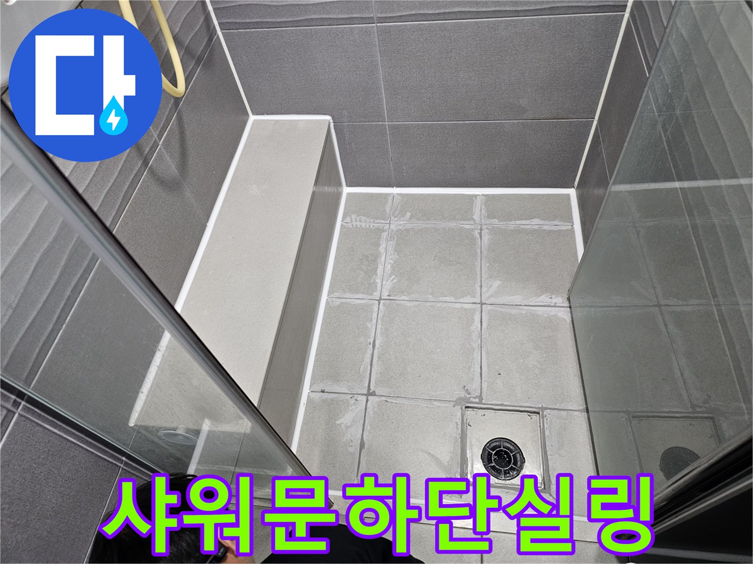 서울 강동구 아파트 욕실의 샤워문 하단에서-누수를 막기 위해-전문가가 방수 실리콘으로 꼼꼼하게 실링하는 모습입니다.