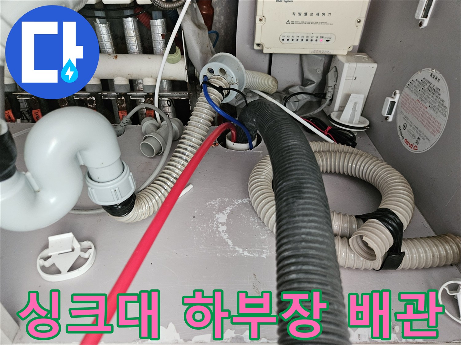 싱크대-하부장-내부의-복잡한-배수관과-연결된-호스들