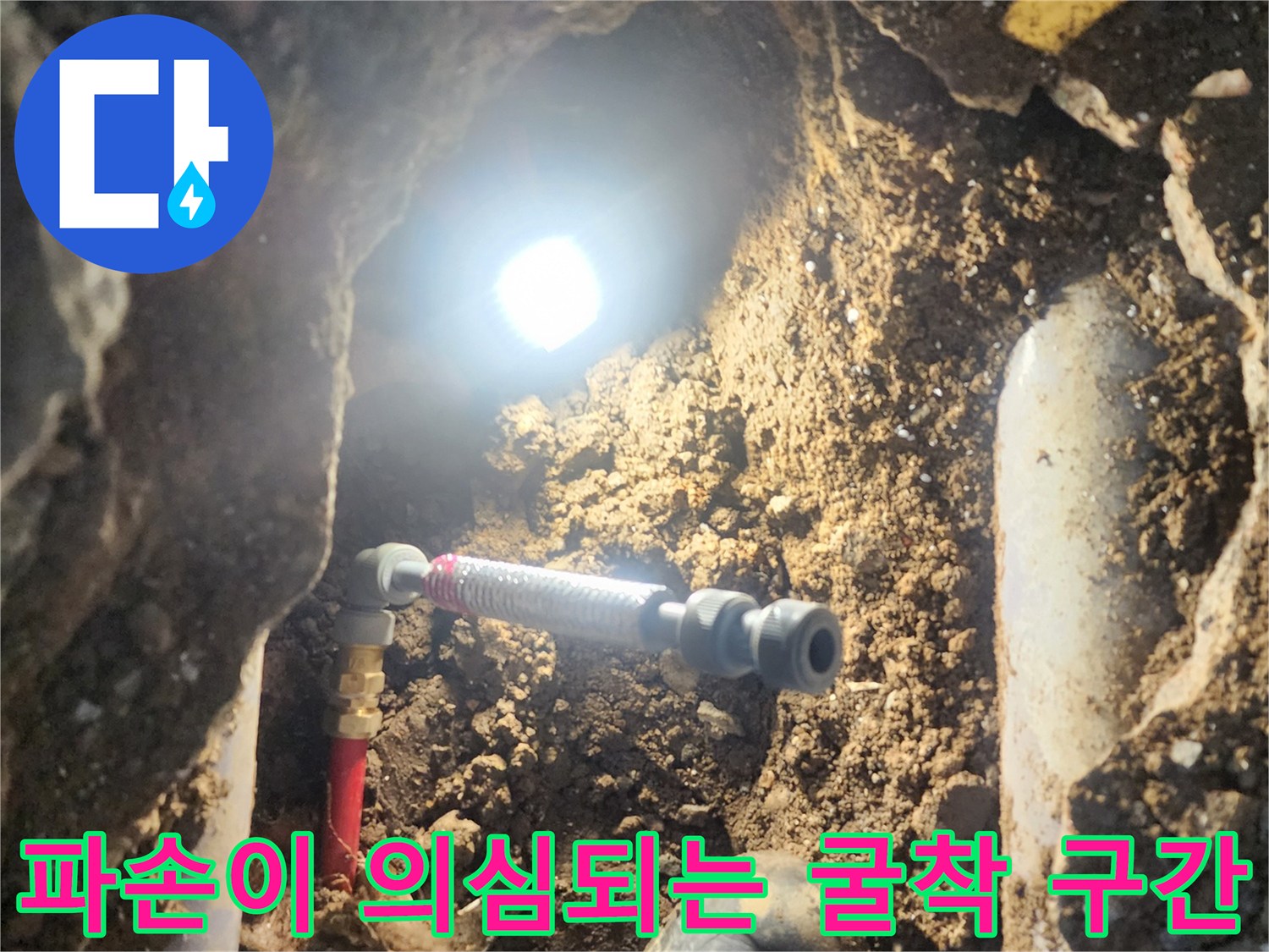 지표면 아래 파헤쳐진 배관을 확인하고 교체할 준비를 하는 장면