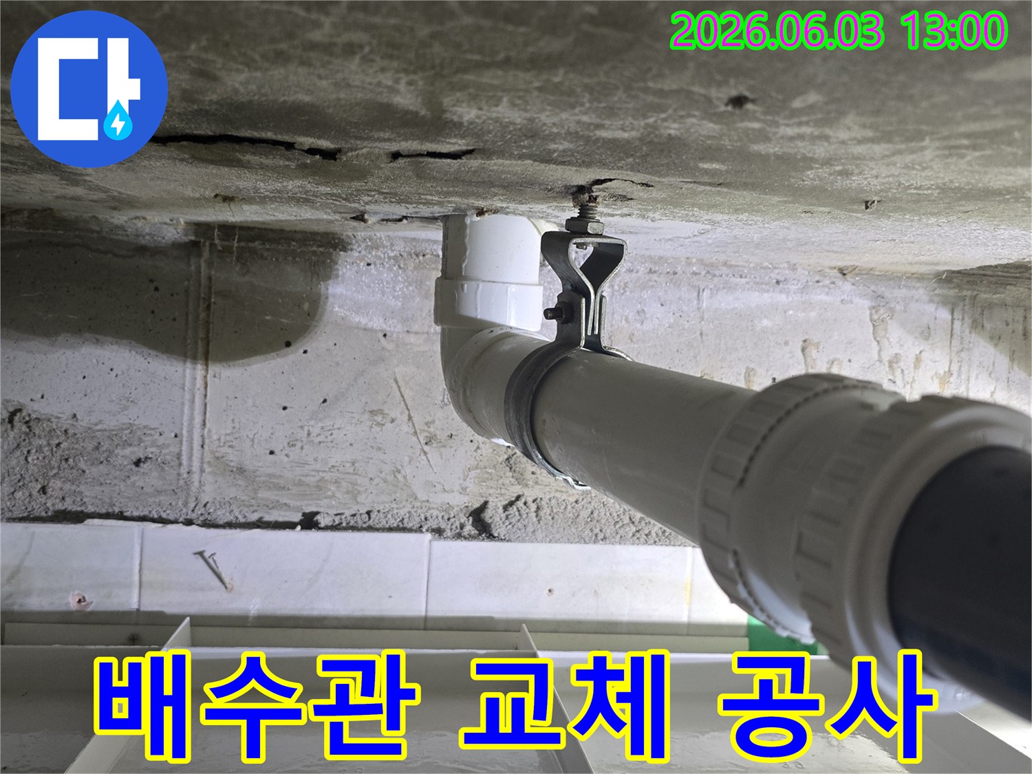 콘크리트 벽에 새로운 배수관이 견고하게 설치된 모습-전문적인 시공 현장입니다.