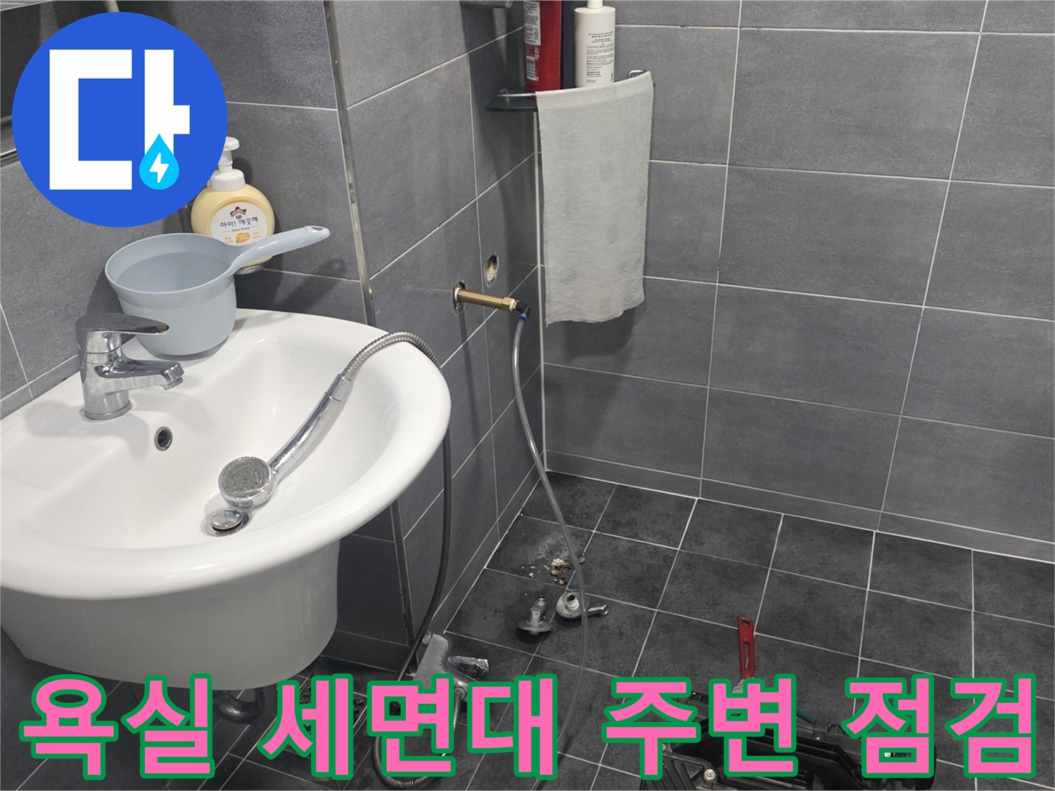 세면대 아래쪽 샤워기 수전과 바닥 타일의 배수구 모습