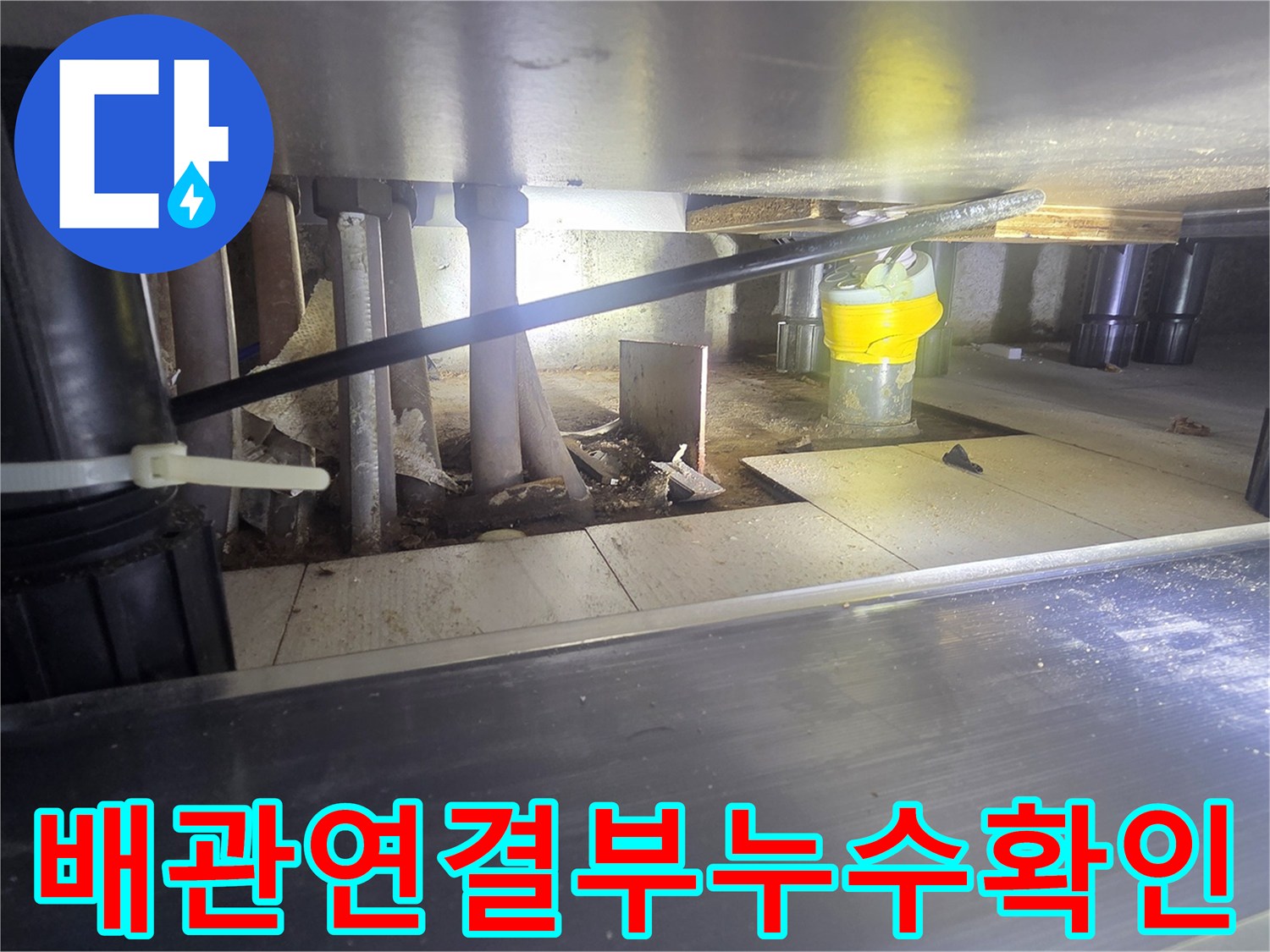 싱크대 밑 배관 사이의 틈새와 연결 부위를 집중적으로 촬영한 사진입니다.