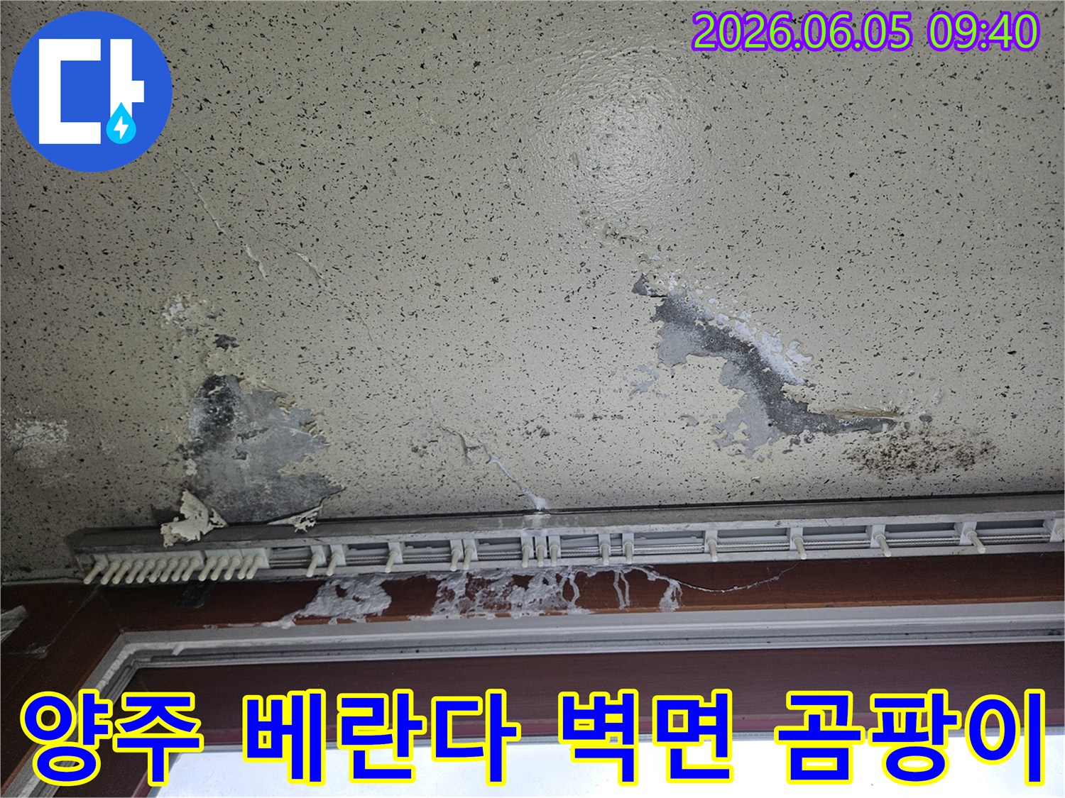 아파트 베란다 벽면이 물에 젖어 벽지가 들뜨고-검은 곰팡이가 피어난 모습으로-베란다 누수와 습기 문제를 보여줍니다.