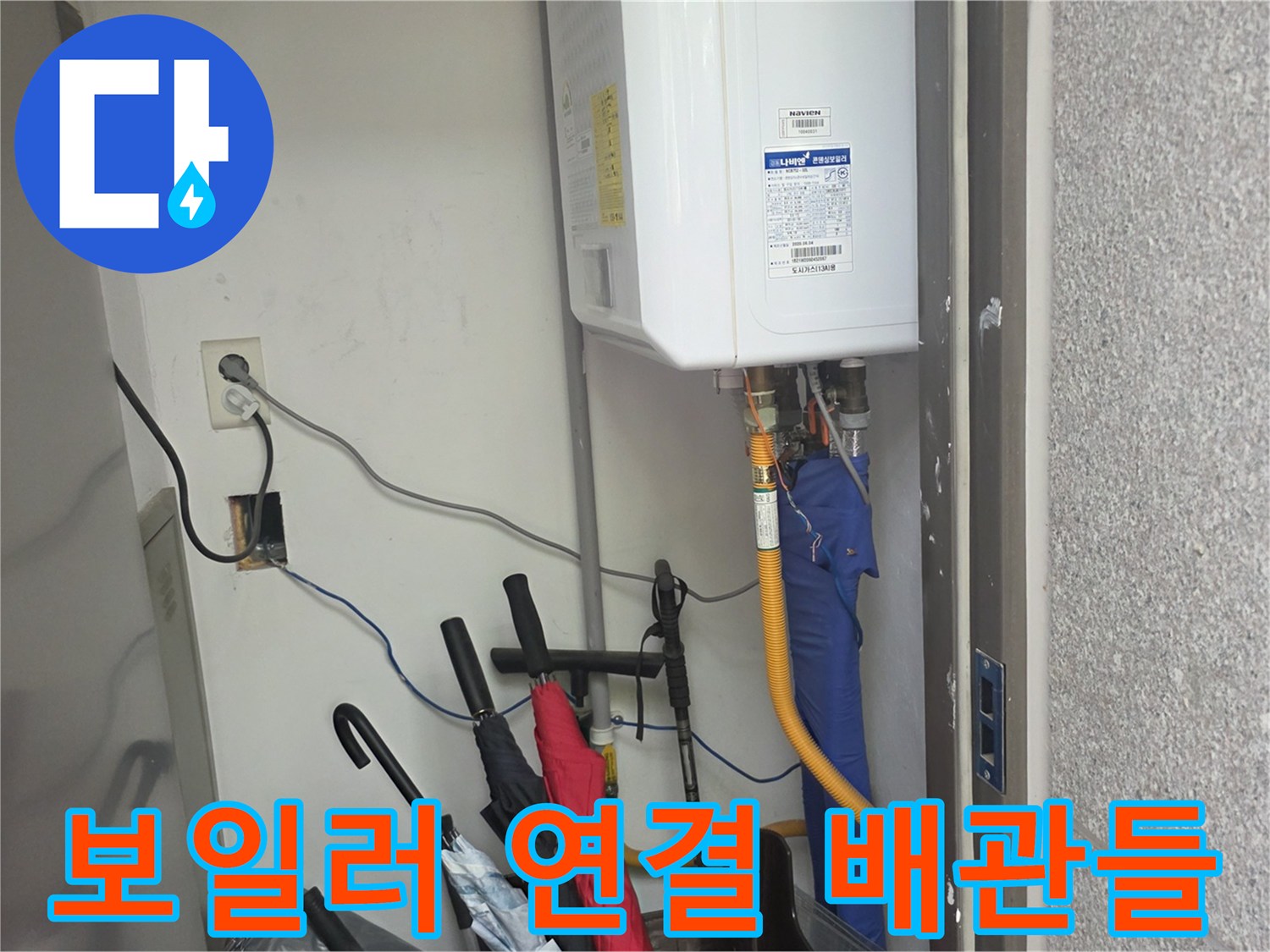 가스보일러 하단부의 복잡한 배관 및 전기 콘센트 모습