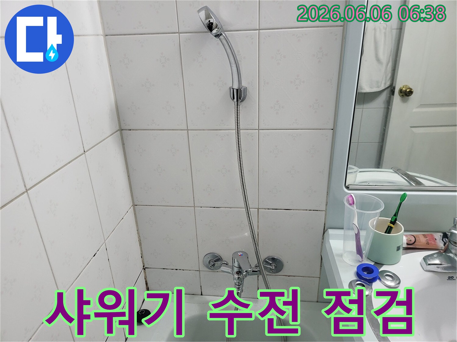욕조-위-설치된-샤워기-수전과-호스-그리고-타일-벽면을-촬영한-사진입니다