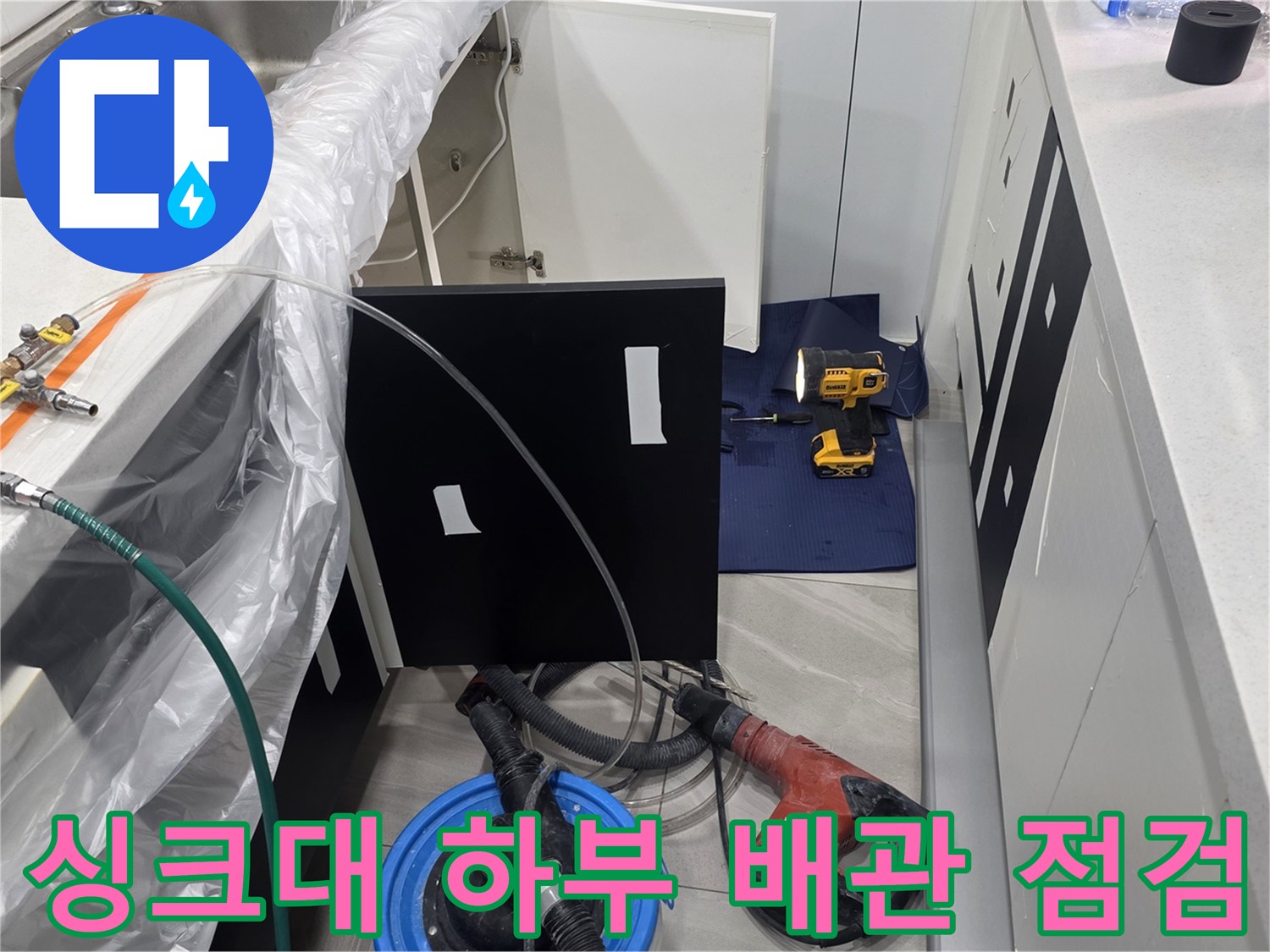 싱크대 아래 설치된 압력계와 연결 호스를 통한 배관 누수 진단 상황입니다.