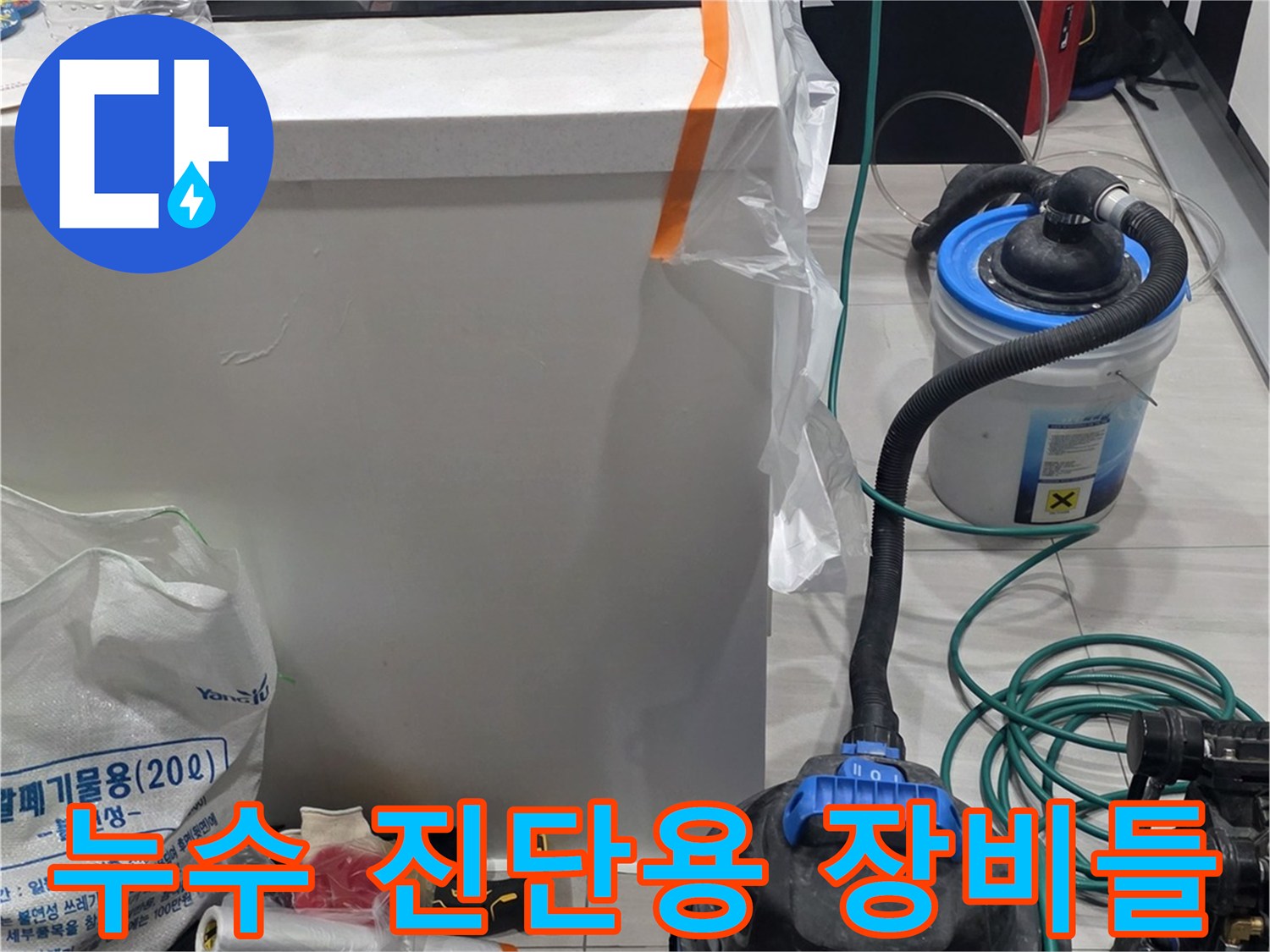 싱크대 아래 작업 공간에 놓인 누수 탐지용 전문 기기들