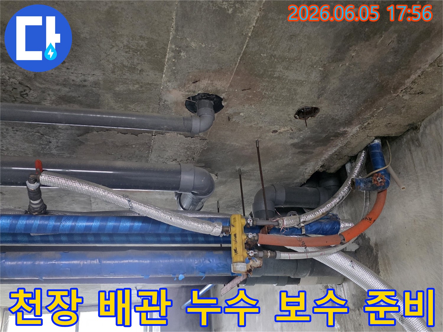 콘크리트-천장-아래-설치된-다양한-배관들의-복잡한-모습-누수-탐지-전문가가-현장을-면밀히-조사하고-있습니다
