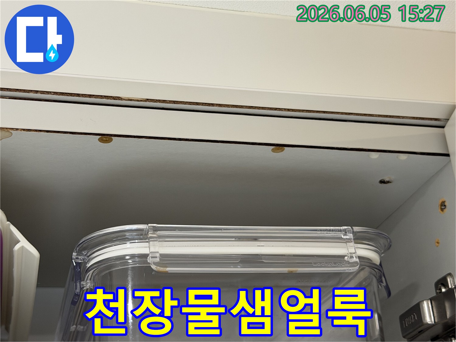 천장 마감재에 생긴 물샘 얼룩과 함께 주변에 나타난 변색-손상된 부분을 담은 이미지입니다.