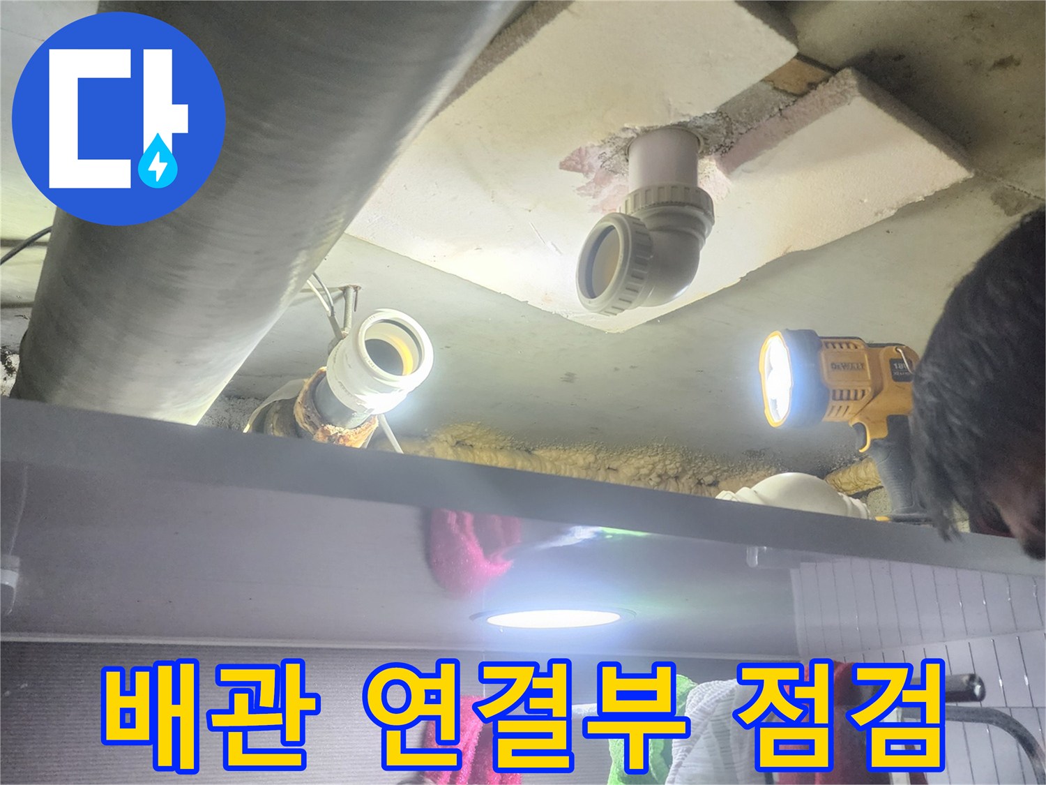 누수 엔지니어가-배관의 연결 부위를-손전등으로 비추며-누수 여부를-집중적으로 점검하는 모습