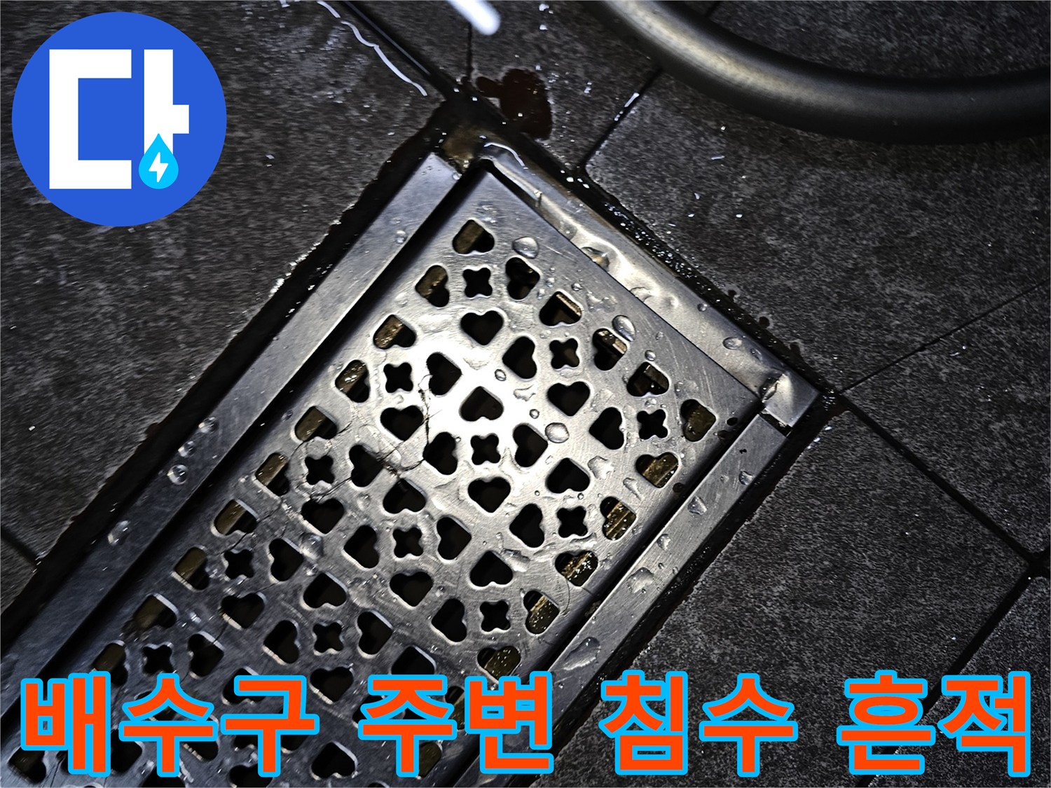 물에 젖은 타일과 금속 배수구 덮개
