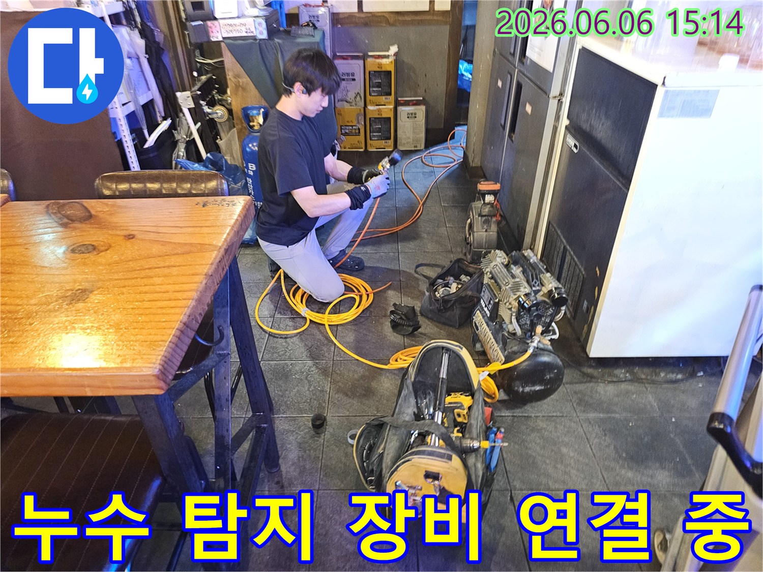 전문 엔지니어가-온수관 누수 해결을 위해-탐지 장비를 연결하고 있습니다.