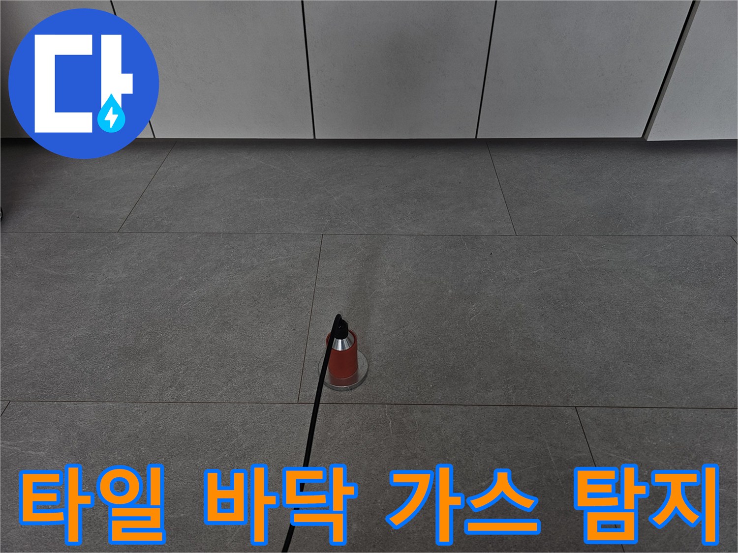 매끄러운 회색 타일 위에 놓인 붉은색 가스 탐지 장치