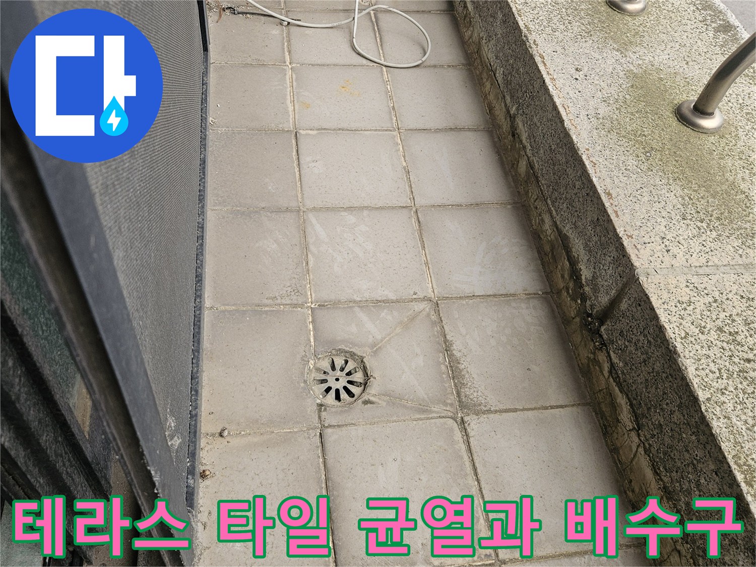 외부 테라스의 노후된 타일 줄눈과 배수구 거름망 상태를 보여주는 사진입니다.