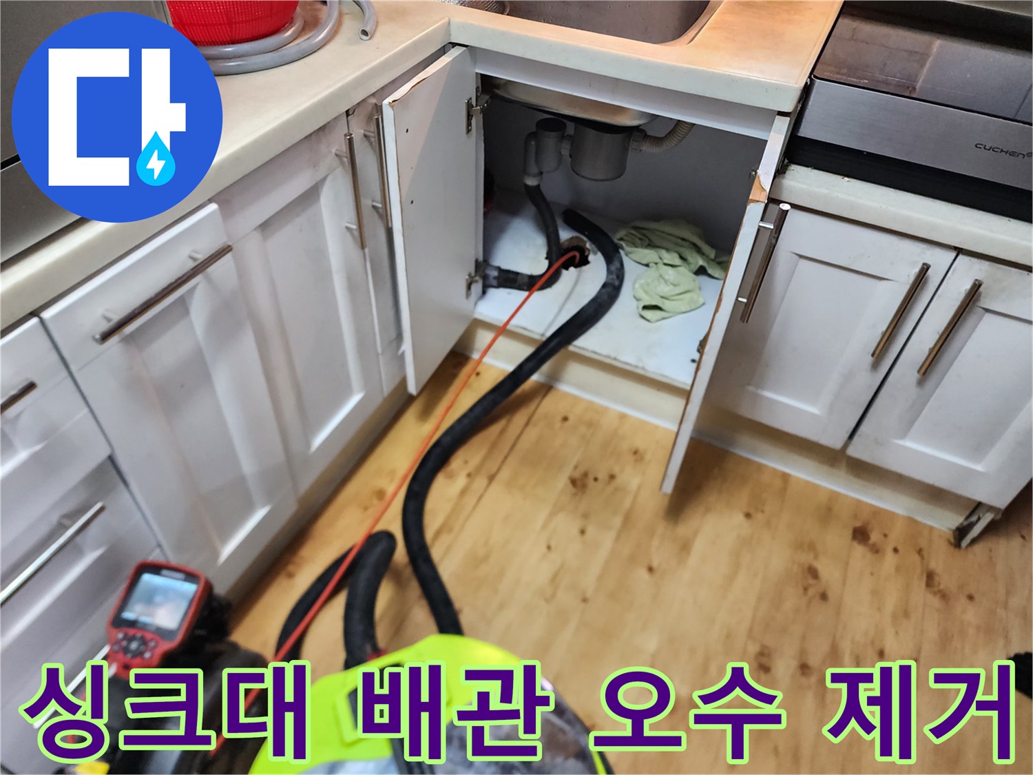 싱크대 하부장 배관에 연결된 석션 호스와 장비의 모습