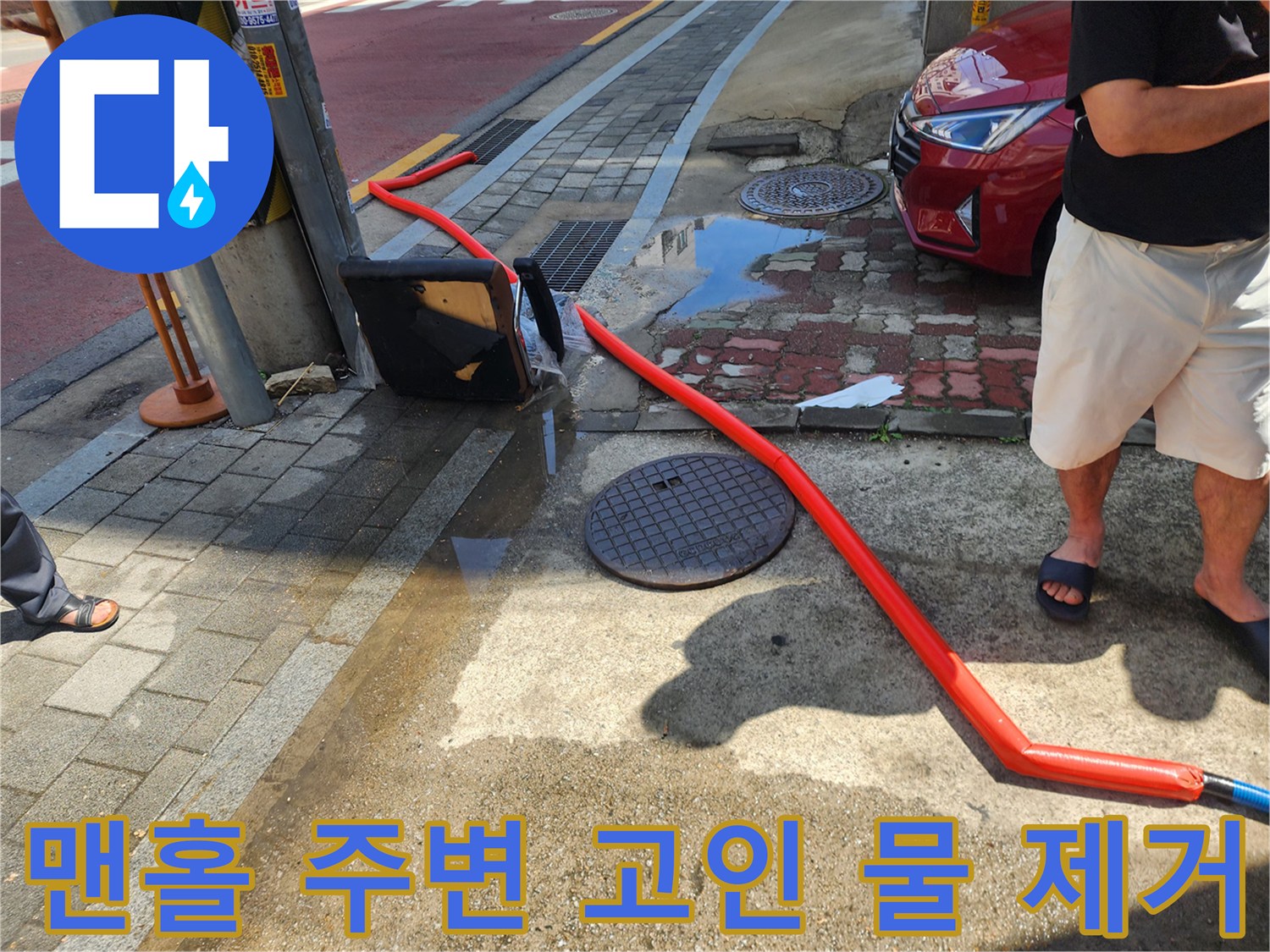 주황색-배수 호스가 맨홀 뚜껑 근처까지 이어져 있는 장면