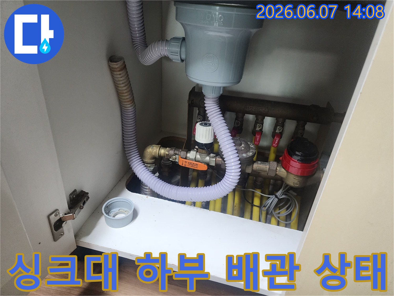 일산서구 대화동 싱크대 하부장 내부의 복잡한 배수관과 주름관 연결 부위 모습입니다.