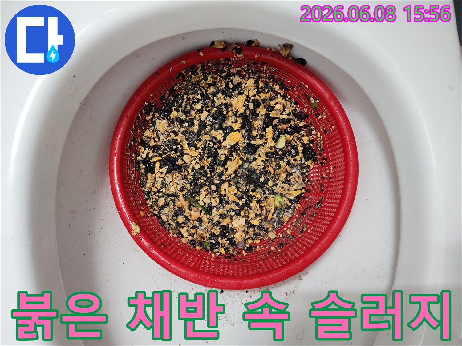 붉은색 배수 거름망에 가득 모인 기름 슬러지 찌꺼기