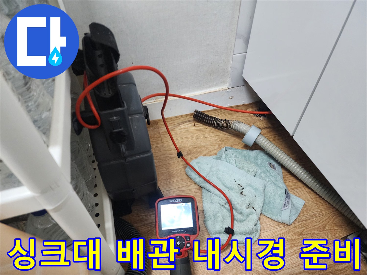 싱크대 하단 배관 점검을 위해 배치된 내시경 모니터와 주변 장비