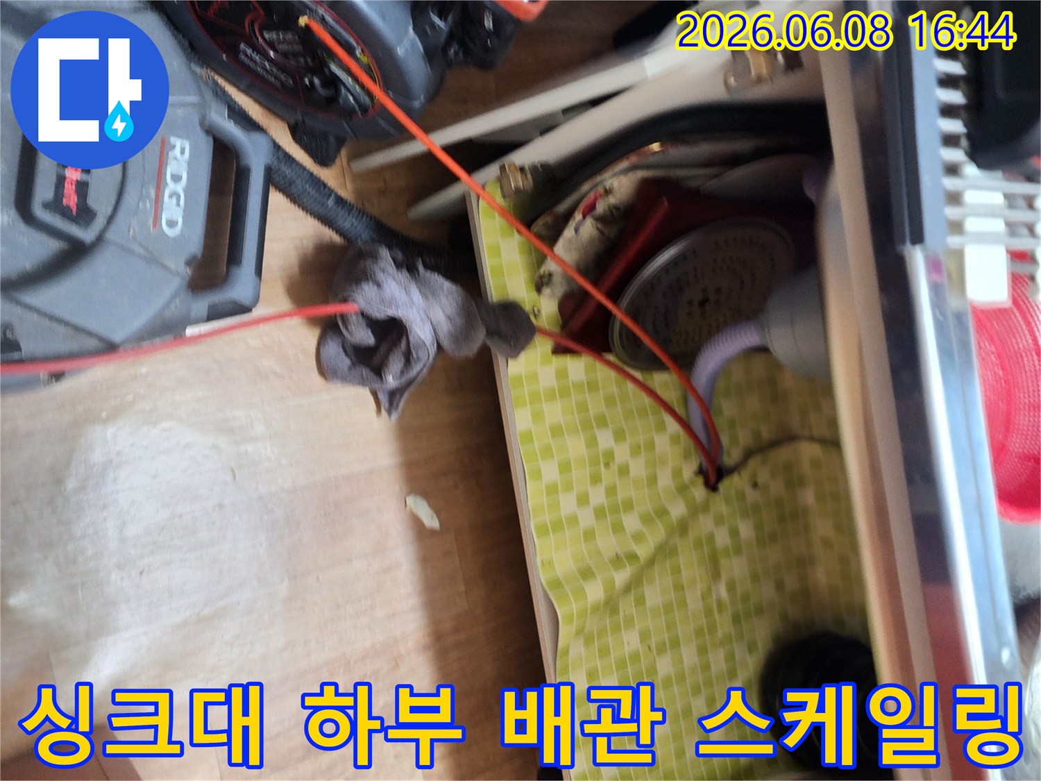 싱크대 아래 배관의 슬러지를 제거하기 위해 전문 장비를 사용 중입니다.