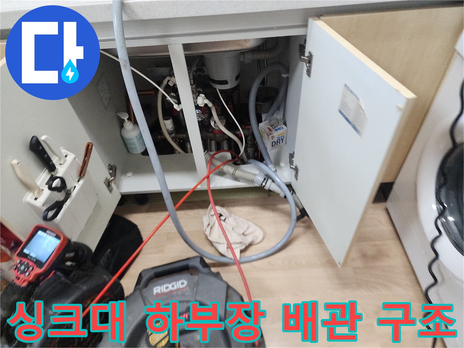 복잡하게 얽힌 싱크대 하수구 배관과 작업용 장비들