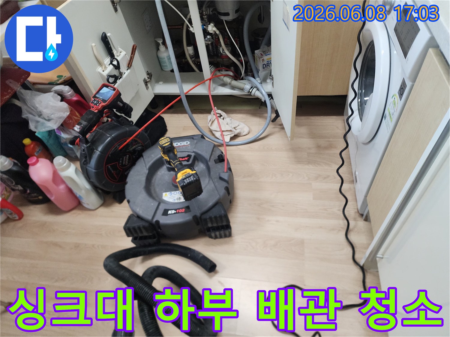 싱크대 아래 복잡한 배관 구조에서 진행되는 스케일링 작업 장면