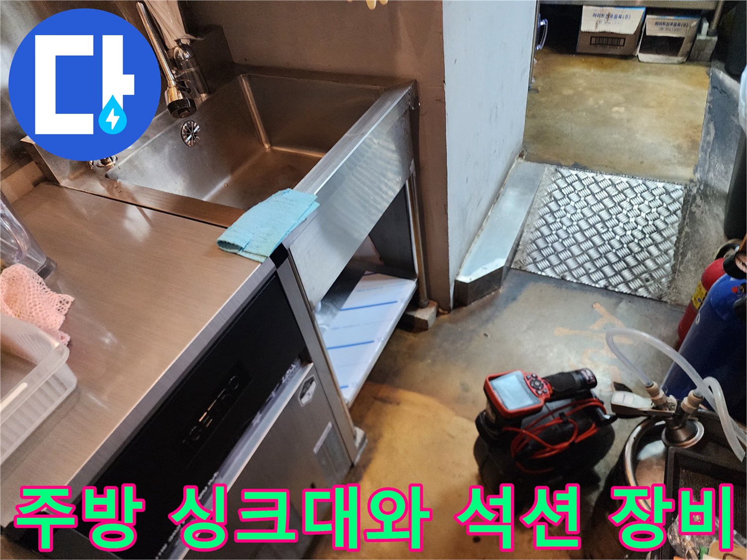 주방 싱크대 하단에 놓인 배관 청소용 석션기 작업 모습