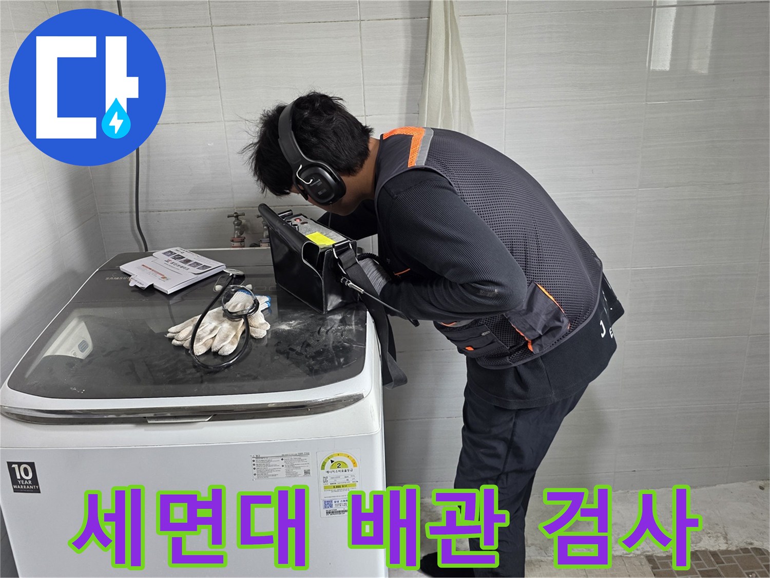 헤드셋을 착용한 작업자가-세면대 아래쪽에서-청음기로 누수를 탐지함