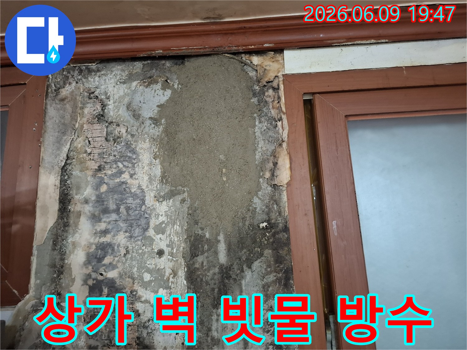 상가 창문 옆 벽체에 발생한 빗물 누수 문제를 해결하기 위해 방수 처리 후 미장으로 보수한 모습