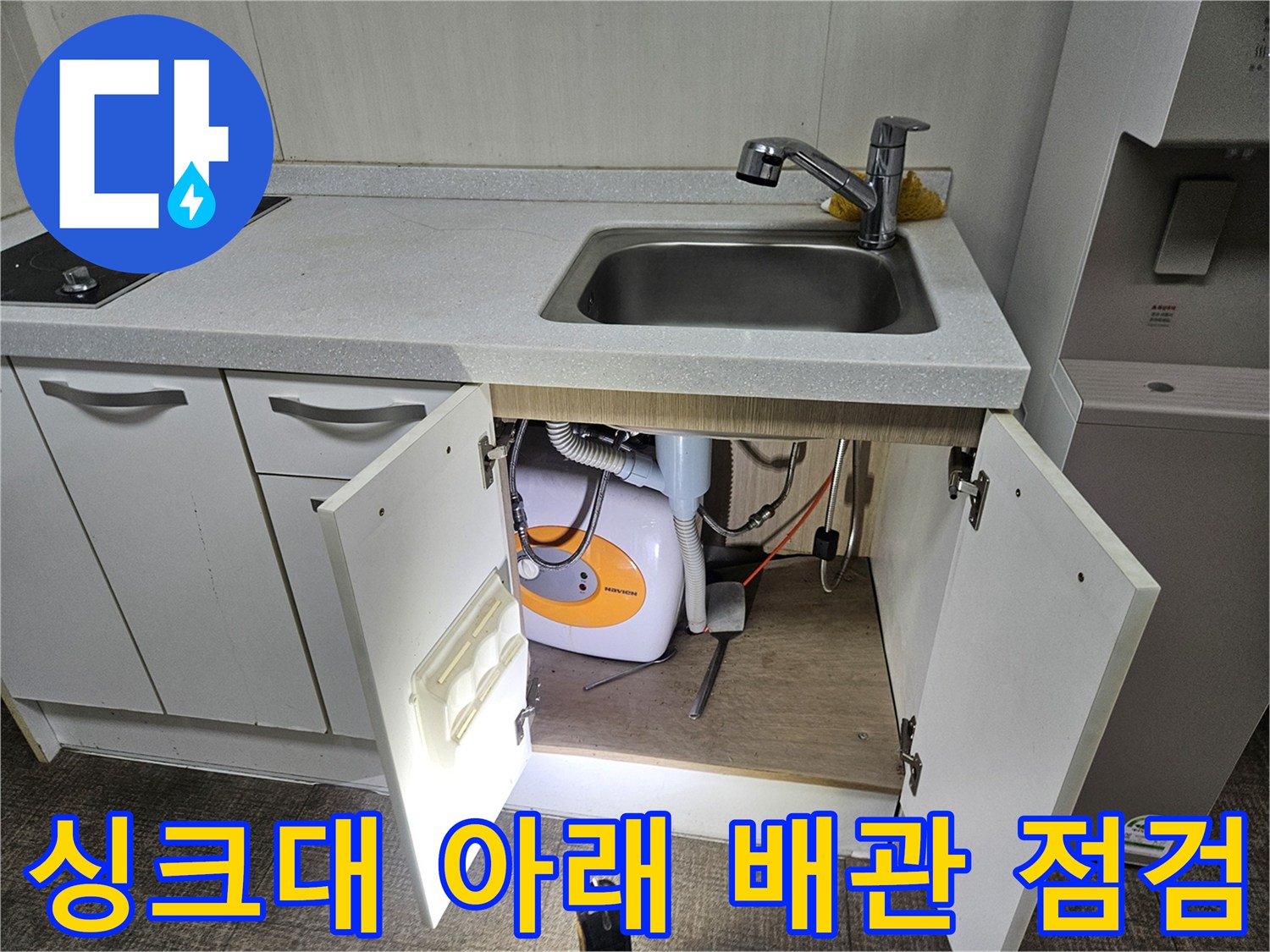 싱크대 하부장 문을 열고 세탁기 급수 및 배수 호스를 점검하는 현장