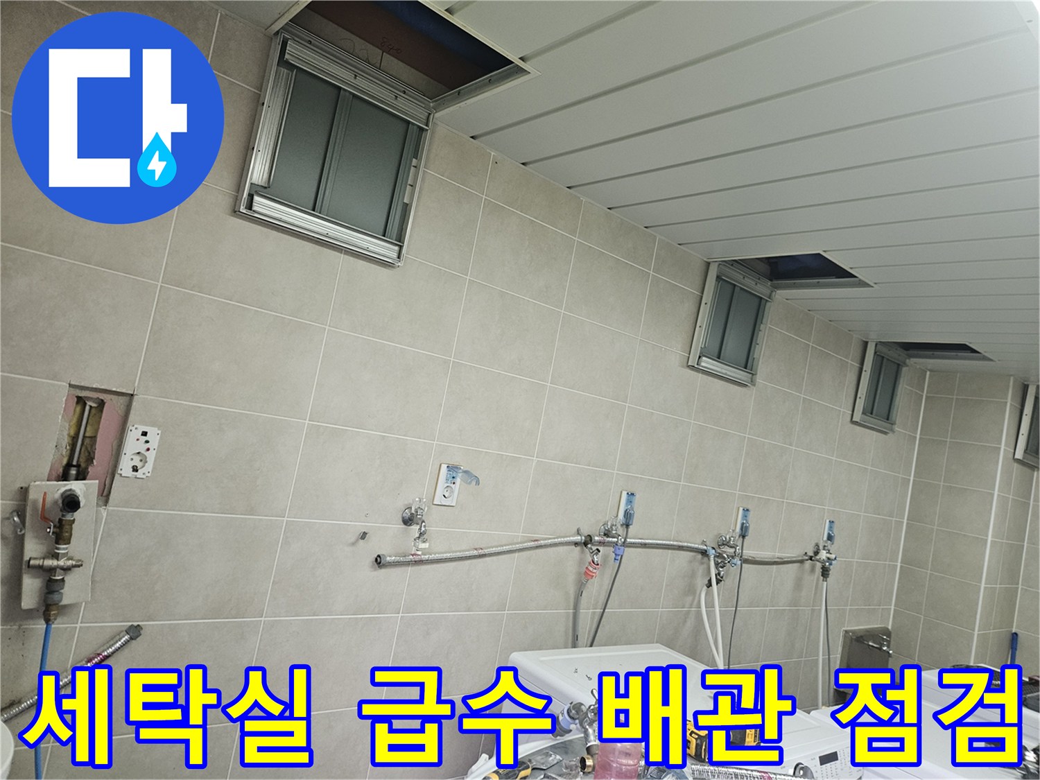 조종면 세탁실-타일 벽면에 설치된 수전 및 배관 연결부