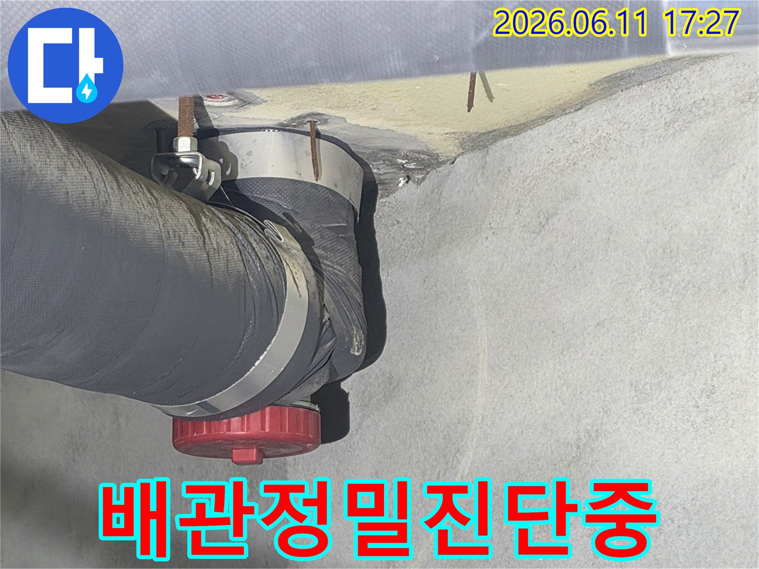 누수 전문가가-배관의 연결 부위와-주변 환경을-세심하게 살펴보는-장면입니다