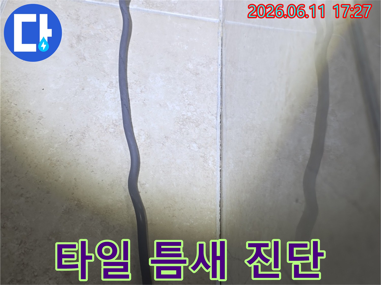 욕실 타일 틈새로 물이 스며들어-벽면에 습기가 올라온 현장을 보여주는 사진입니다