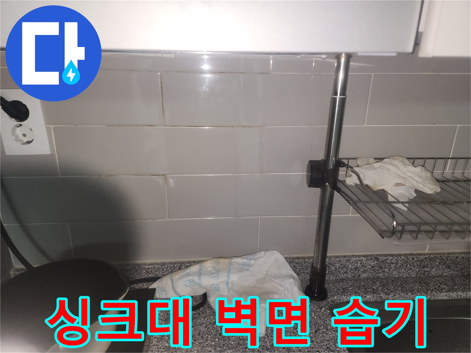 싱크대 주변 타일 벽면에-습기가 스며들어-젖어있는 모습이 포착된 사진