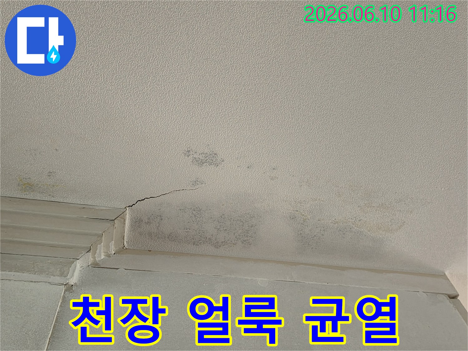 천장 모서리 부분에-물기로 인한-얼룩과-작은 균열이 선명하게 나타난 모습입니다.