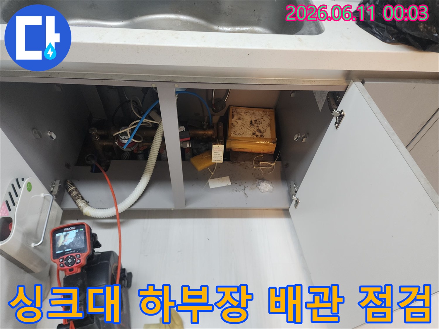싱크대 하부장 내부의 배관과 내시경 장비 모습입니다.