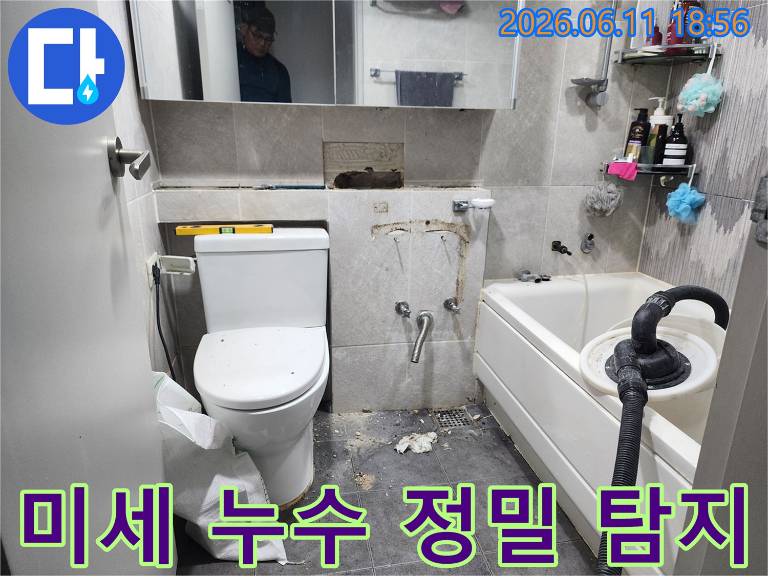 이 이미지는-동대문구의 한 욕실에서-육안으로 확인하기 어려운-미세한 누수 지점을 찾아내기 위해-타일을 제거하고-정밀 탐지 장비를 사용하는-작업 현장을 보여줍니다