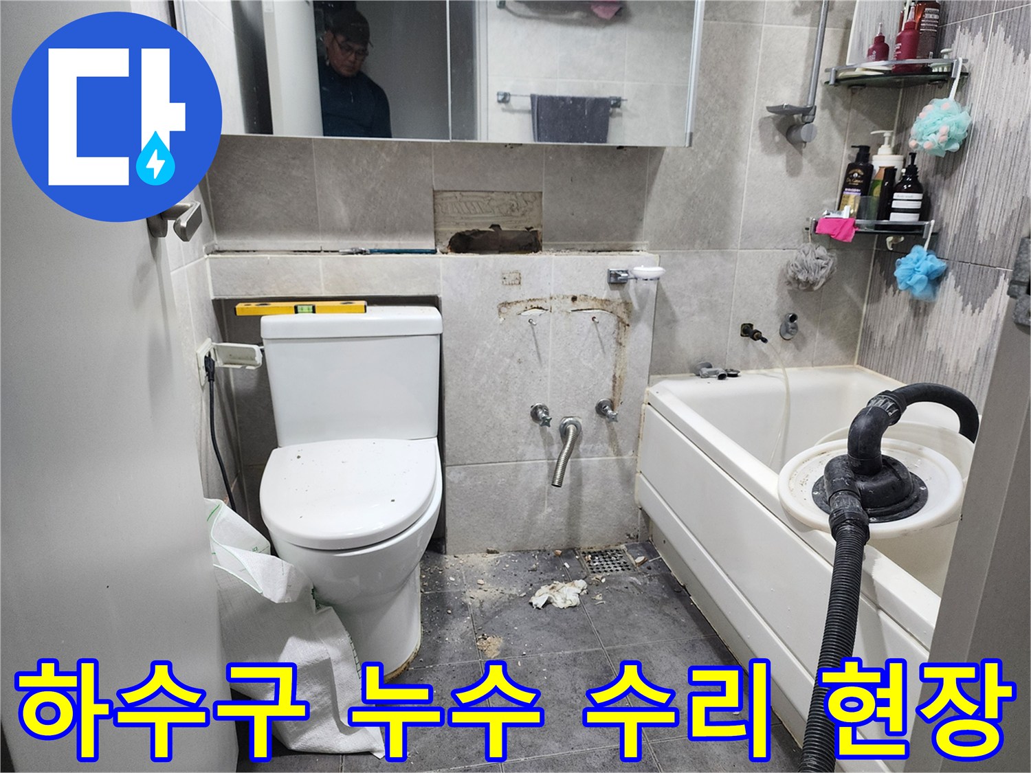 이 이미지는-동대문구의 한 화장실에서-하수구 배관의 누수 문제를 해결하기 위해-바닥 타일을 제거하고-손상된 하수구 배관을 수리하는-작업 현장을 보여줍니다