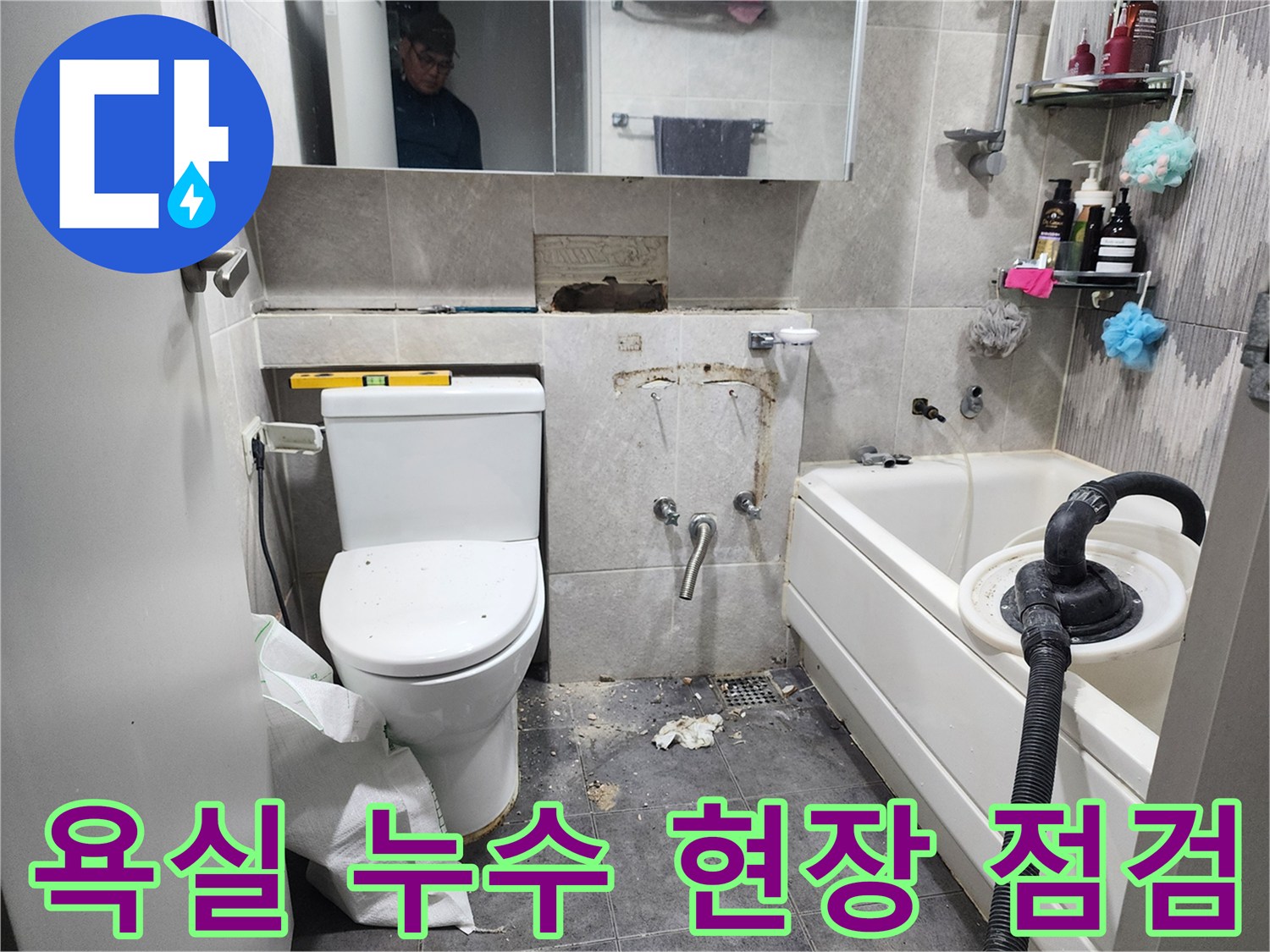 이 이미지는-서울 동대문구 아파트 욕실에서-누수 원인을 찾기 위해-타일을 제거하고-배관 상태를 점검하는-누수 탐지 및 수리 과정을 보여줍니다