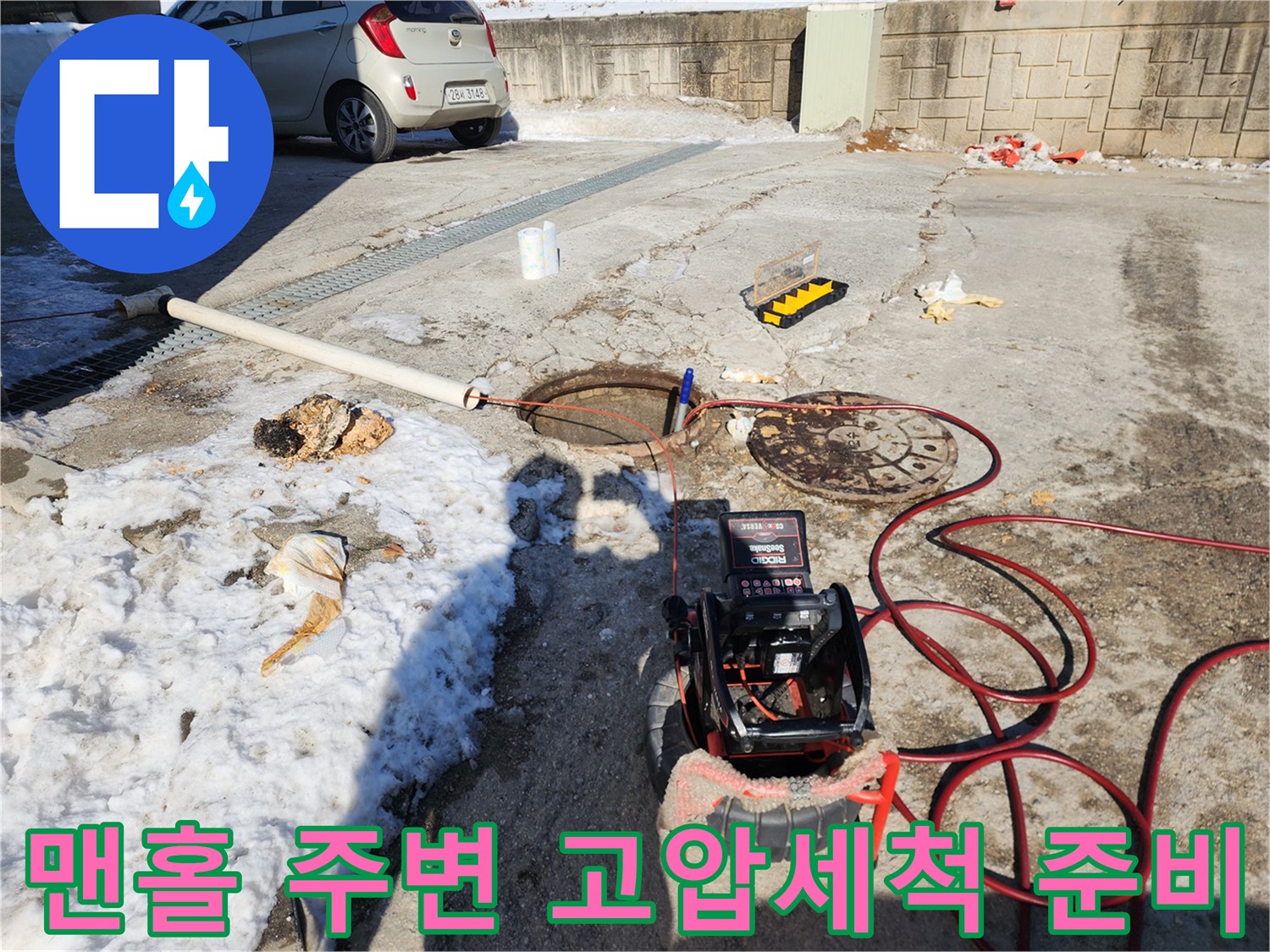 하수구 세척을 위해 배치된 붉은색 고압 호스와 장비들