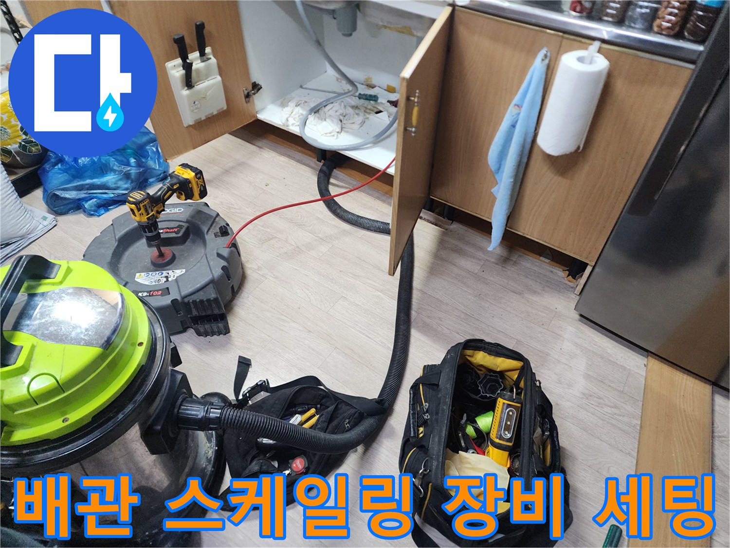 싱크대 배관 청소를 위해 준비된 석션기와 전동 공구 가방